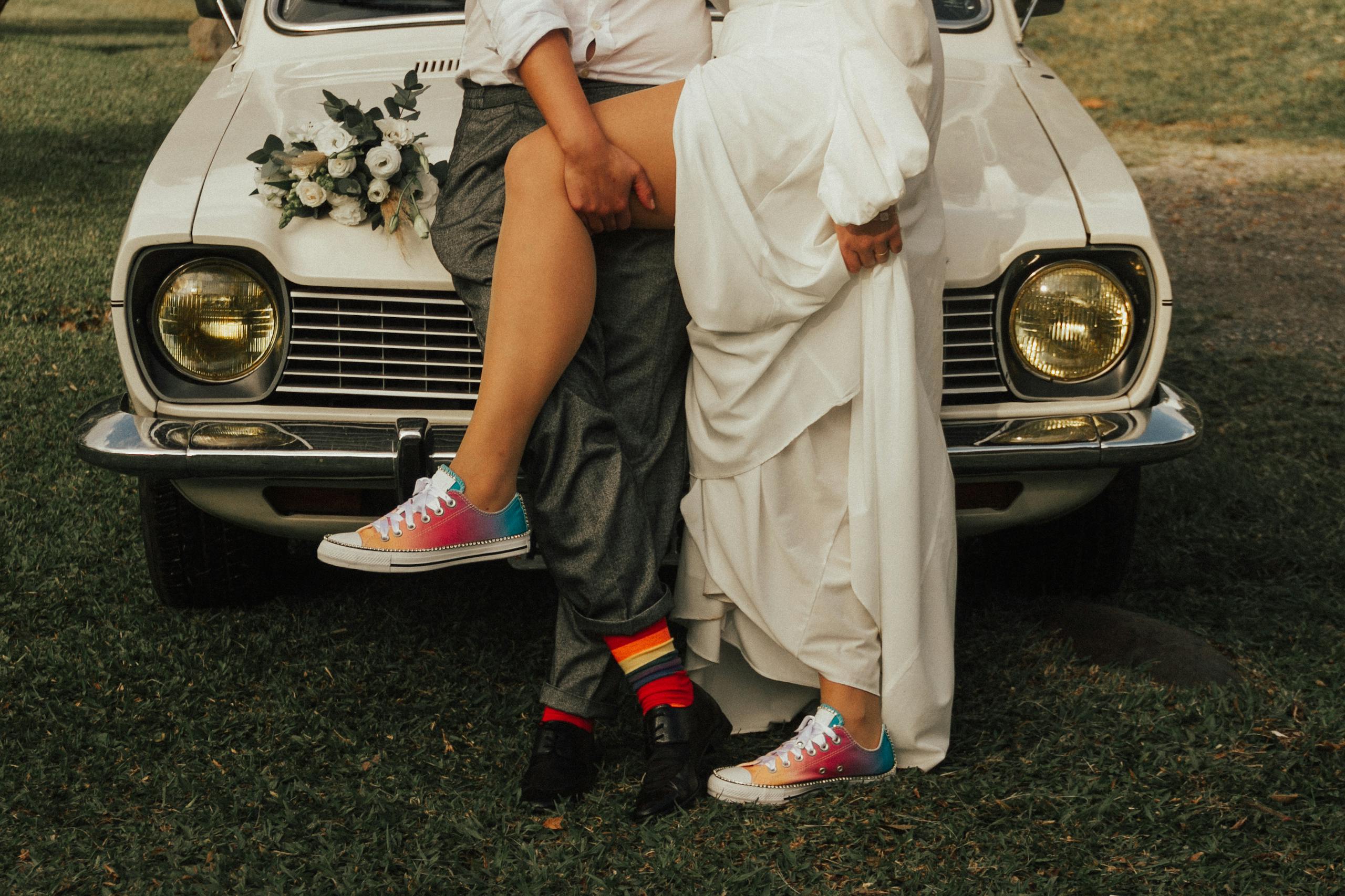 Bride and groom in matching white sneakers laughing on their wedding day